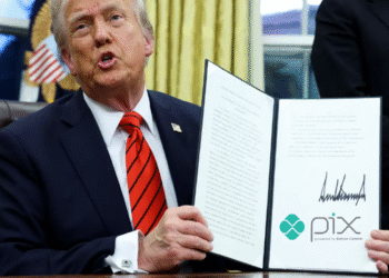 Donald Trump segurando um documento com sua assinatura, durante um discurso sobre uma investigação contra o Brasil e o Pix.