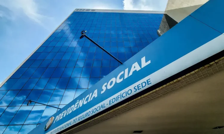 Fachada espelhada da sede do INSS com letreiro da Previdência Social