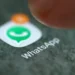 Ícone do aplicativo WhatsApp na tela de um smartphone, com dedo prestes a tocar.