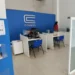 Atendimento ao cliente na CORSAN em Passo Fundo, com cubículos e sinalização de espera."