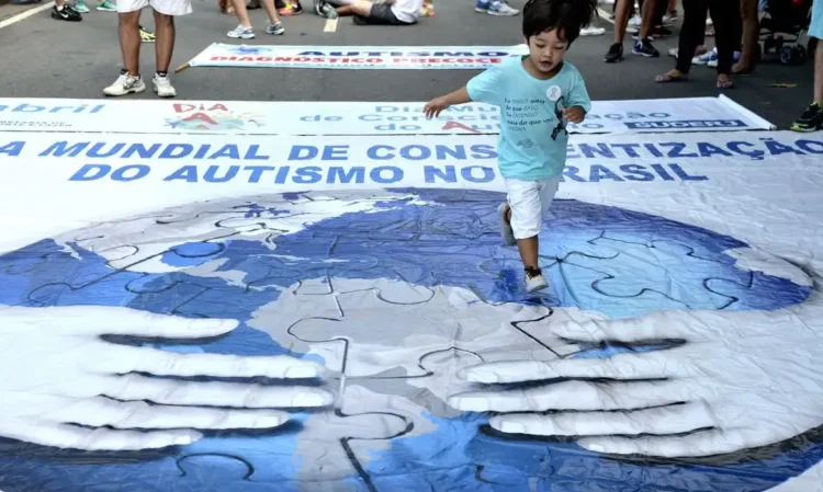 Criança caminha sobre banner de conscientização do autismo