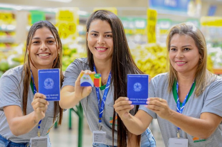 Mulheres exibindo cartões do Bolsa Família em supermercado