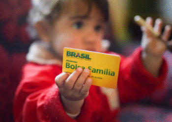 Criança segurando cartão do Bolsa Família 2025.