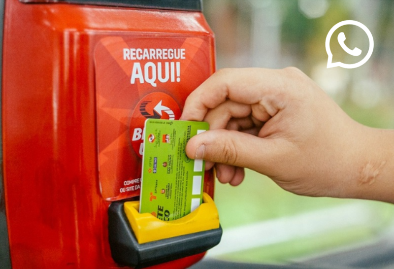 Pessoa fazendo recarga do Bilhete Único em terminal de ônibus com cartão.