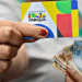 Cartão do Bolsa Família e dinheiro em notas de reais, relacionado à consulta sobre recebimento do benefício em agosto.