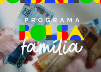 Notas de 100 e 50 reais sendo entregues, com a logo do Programa Bolsa Família ao fundo, referente a famílias que perderam o benefício em julho.