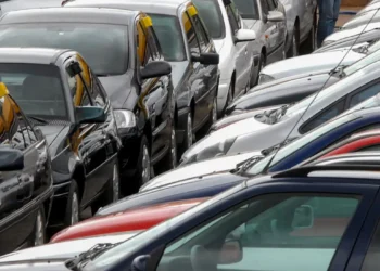 Carros populares estacionados em fila em pátio de revendedora