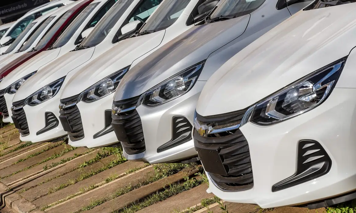 Fila de carros novos prontos para venda com destaque no imposto