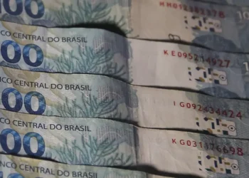 Cédulas de 100 reais empilhadas, representando o uso de dinheiro físico.