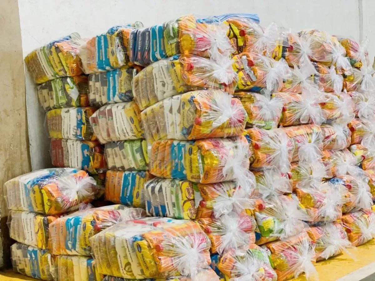 Cestas básicas empilhadas em sacos plásticos, preparadas para distribuição na Bahia.