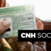 CNH Social 2025: Carteira Nacional de Habilitação gratuita sendo segurada dentro de um carro.