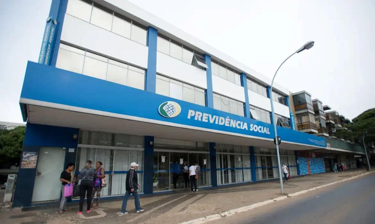 Fachada de uma agência do INSS, com o nome 'Previdência Social' em destaque, simbolizando o atendimento à população.