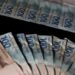 Notas de 100 e 200 reais representando faixas salariais do piso regional