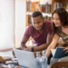 Estudantes colaborando em um projeto de computador, representando o processo de acessar informações importantes para o Encceja 2025.