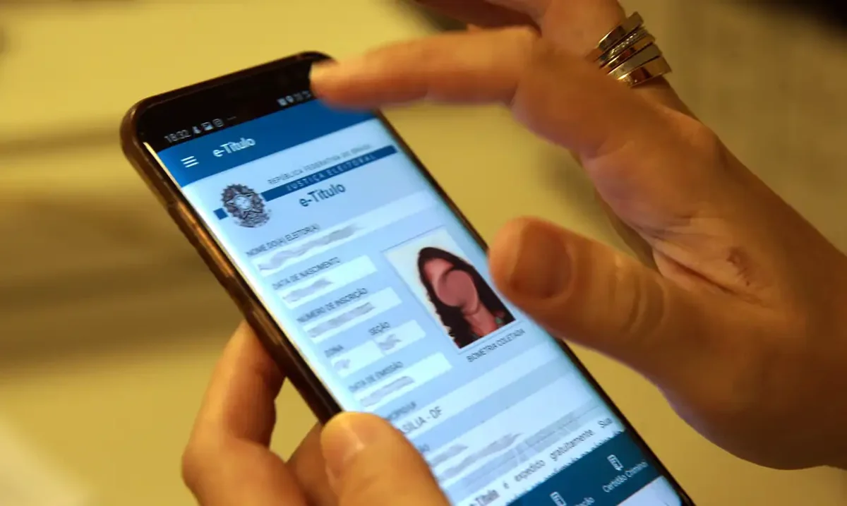 Pessoa acessando a atualização da foto do e-Título no aplicativo de celular em 2025.