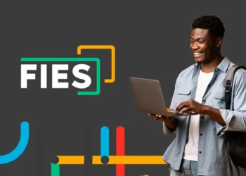 Estudante sorrindo com laptop, representando inscrições FIES 2025/2.