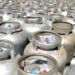 Botijões de gás empilhados em área de distribuição.