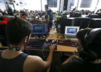 Jovens participam de atividade digital em ambiente colaborativo com computadores
