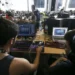 Jovens participam de atividade digital em ambiente colaborativo com computadores