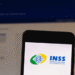 Logo do INSS na tela de smartphone com tema sobre mutirões para agilizar o BPC/LOAS