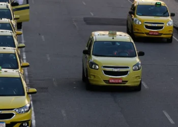 Taxis amarelos enfileirados em rua urbana