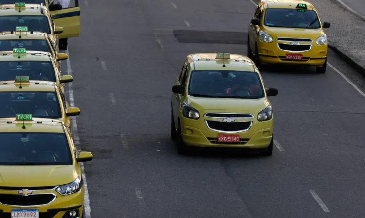 Taxis amarelos enfileirados em rua urbana
