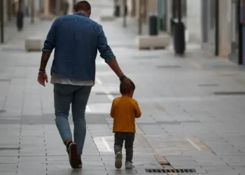 Pai e filho caminhando juntos em uma rua tranquila, simbolizando o apoio e a união familiar no mutirão gratuito de testes de DNA.