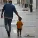 Pai e filho caminhando juntos em uma rua tranquila, simbolizando o apoio e a união familiar no mutirão gratuito de testes de DNA.