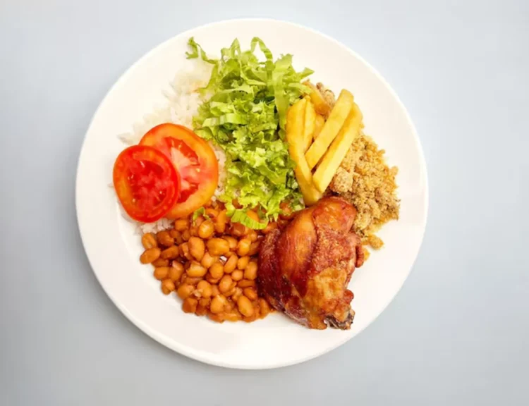 Prato com arroz, feijão, frango assado, salada e batata, simbolizando refeição garantida pelo cartão-alimentação