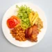Prato com arroz, feijão, frango assado, salada e batata, simbolizando refeição garantida pelo cartão-alimentação