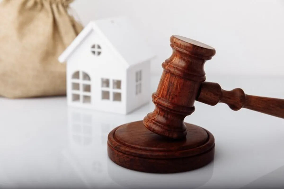 Martelo de leilão e miniatura de casa, simbolizando os imóveis nos leilões da Caixa Econômica Federal.