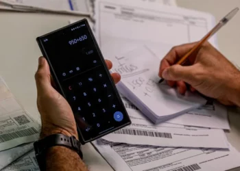 Pessoa utilizando calculadora para renegociar dívidas com desconto de até 97% no Mutirão Serasa 2025