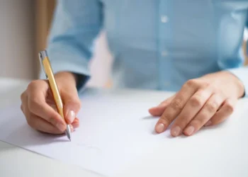 Pessoa assinando documento importante sobre partilha de bens no inventárioPessoa assinando documento importante sobre partilha de bens no inventário
