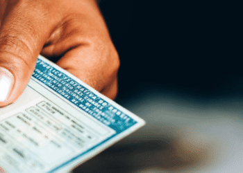 Pessoa segurando e entregando a Carteira Nacional de Habilitação (CNH)