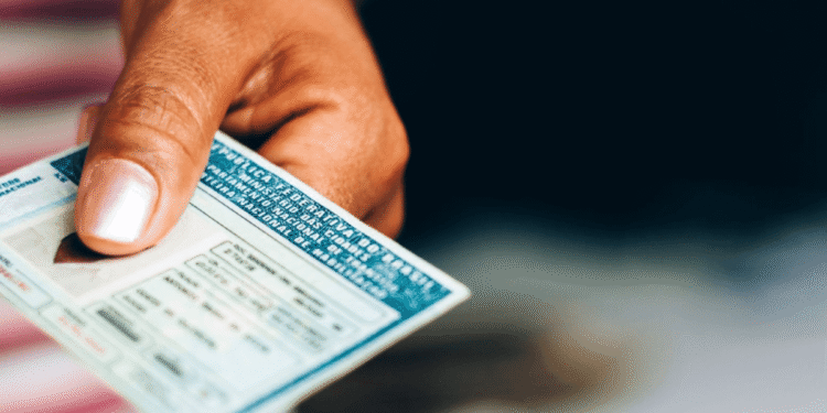 Pessoa segurando e entregando a Carteira Nacional de Habilitação (CNH)