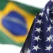 Bandeira dos Estados Unidos em primeiro plano com a bandeira do Brasil ao fundo, simbolizando os impactos do tarifaço americano nos preços e no cotidiano.