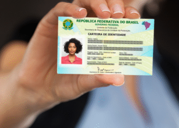 Uma mão segurando a nova Carteira de Identidade Nacional, destacando a foto e os dados.