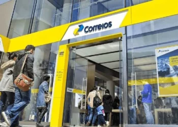 Imagem da fachada de uma agência dos Correios com várias pessoas na fila, representando o atendimento ao cidadão para a criação e segurança da conta Gov.br.