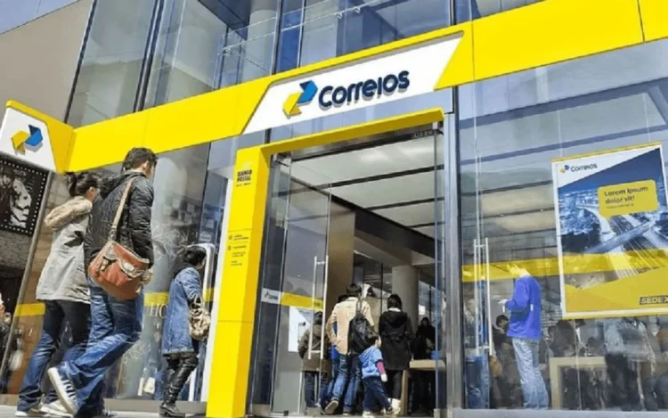 Imagem da fachada de uma agência dos Correios com várias pessoas na fila, representando o atendimento ao cidadão para a criação e segurança da conta Gov.br.