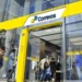 Imagem da fachada de uma agência dos Correios com várias pessoas na fila, representando o atendimento ao cidadão para a criação e segurança da conta Gov.br.