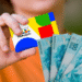 Beneficiário segura cartão do Bolsa Família junto a notas de 100 reais