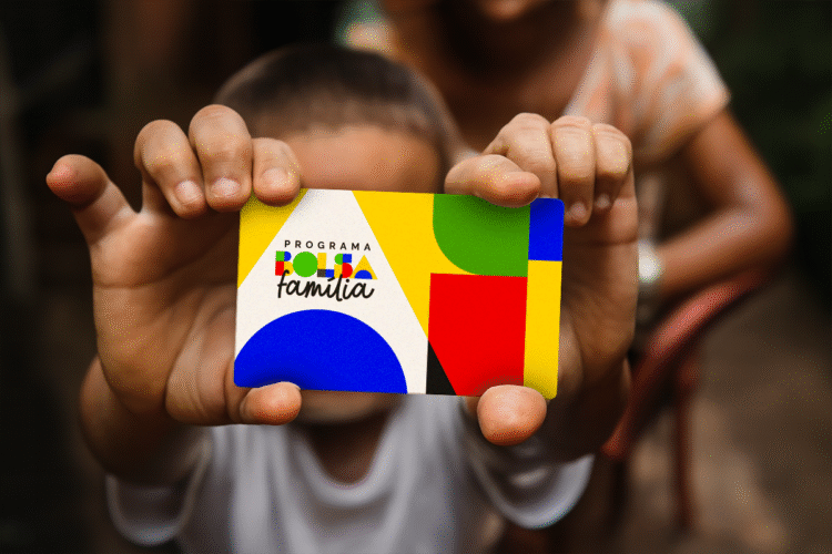 Cartão do Programa Bolsa Família com design colorido e com pessoas no fundo.