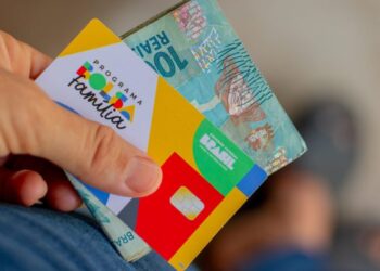 Cartão do Programa Bolsa Família e nota de R$100.