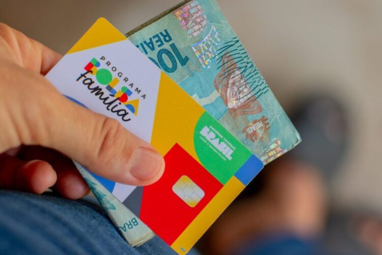 Cartão do Programa Bolsa Família e nota de R$100.