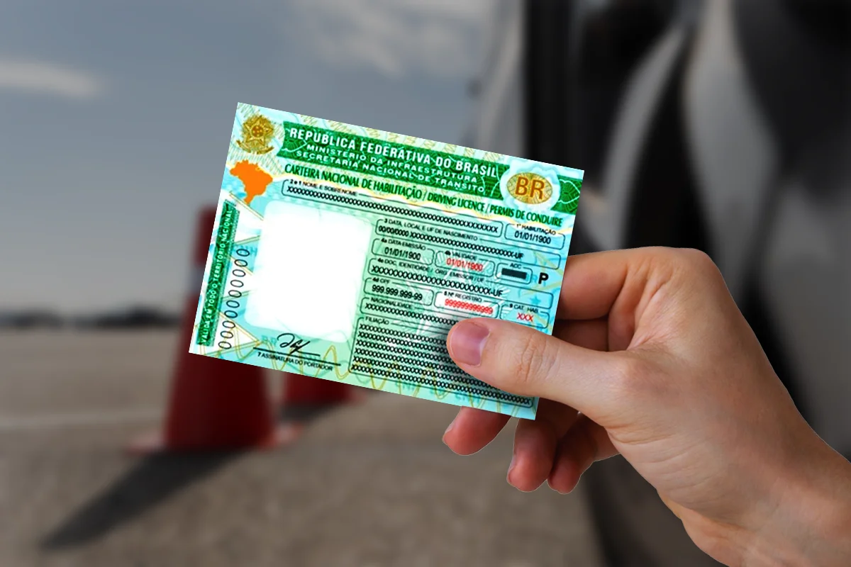 Carteira Nacional de Habilitação brasileira em mãos, representando um dos documentos necessários para inscrição.