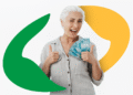 Idosa sorrindo e segurando cédulas de 100 reais, simbolizando a devolução de valores do INSS.
