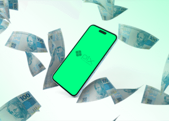 Celular com tela do Pix cercado por notas de cem reais.