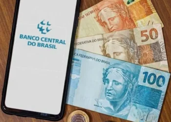 Imagem do Banco Central do Brasil mostrando notas de R$ 100, R$ 50, e moedas, com um celular exibindo o logo do Banco Central, sobre dinheiro esquecido.