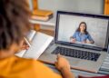 Pessoa comparando opções de plataformas de cursos gratuitos com notebook e anotações.