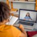 Pessoa comparando opções de plataformas de cursos gratuitos com notebook e anotações.